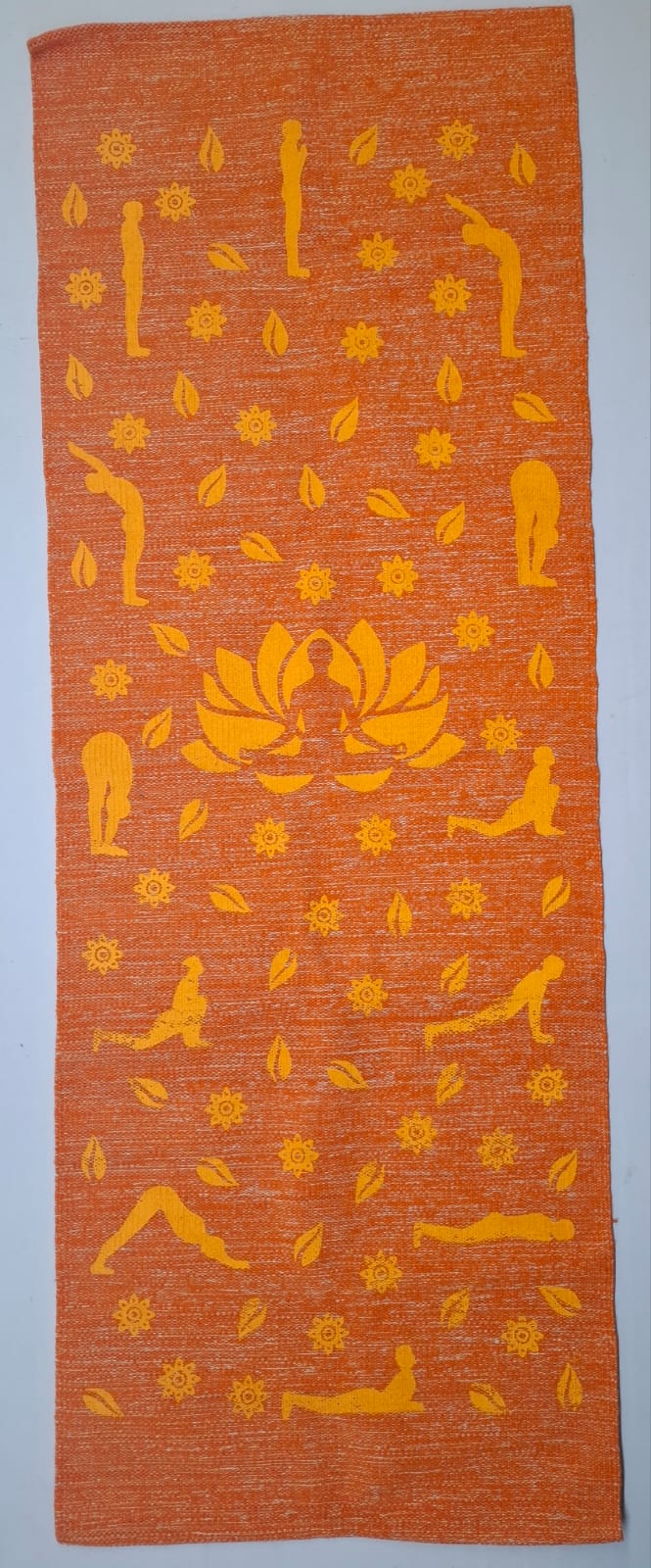 An orange eco-friendly cotton yoga mat printed with yellow Surya Namaskar poses.