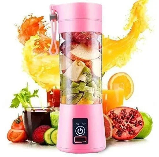 A pink portable electric blender with a clear body filled with chopped kiwi and apples, surrounded by fresh produce like pomegranate, tomatoes, oranges, and glasses of juice, with a dynamic orange juice splash in the background.