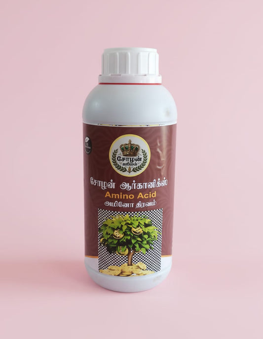 A white plastic bottle of Cholan Organics Amino Acid liquid, featuring a brown label with Tamil and English text and an illustration of a green tree growing gold coins, set against a solid light pink background.