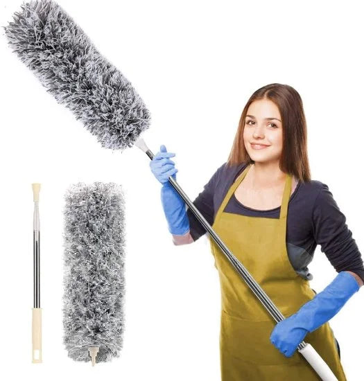 A smiling woman wearing an apron and blue gloves holding a long extendable telescopic duster with a fluffy grey head, displayed next to the detached handle and duster head.