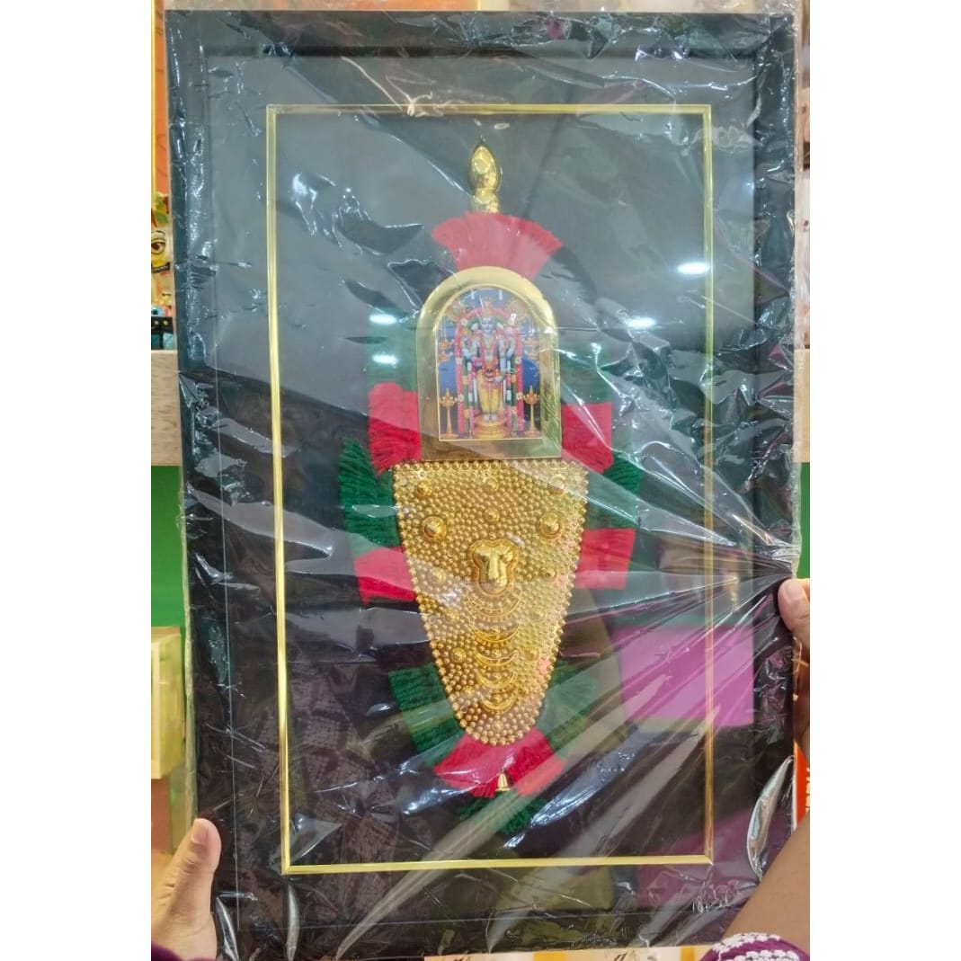 A framed traditional wall art piece depicting the golden ornament of Lord Tirupati Balaji, featuring intricate embossed details and accented with red and green against a black background.