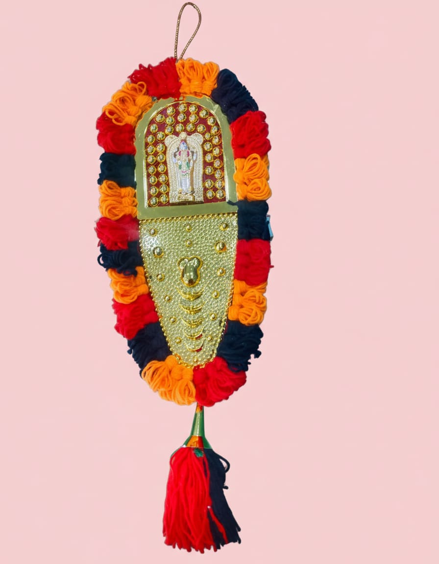 A traditional wall hanging ornament featuring a golden embossed Balaji design in the center, bordered by bright red, orange, and black woolen accents, complete with a matching bottom tassel.