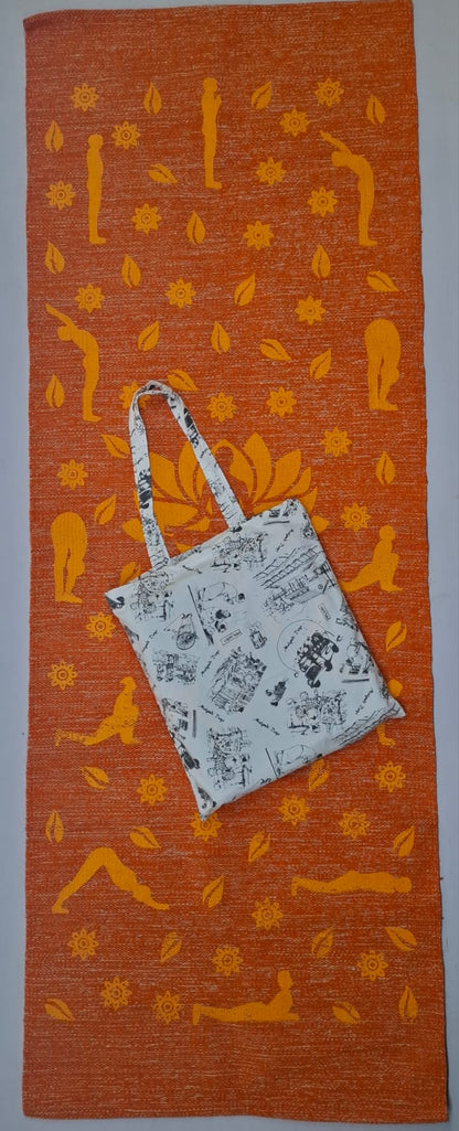 An orange eco-friendly cotton yoga mat printed with yellow Surya Namaskar poses, shown with a matching printed light-colored tote bag resting on top.